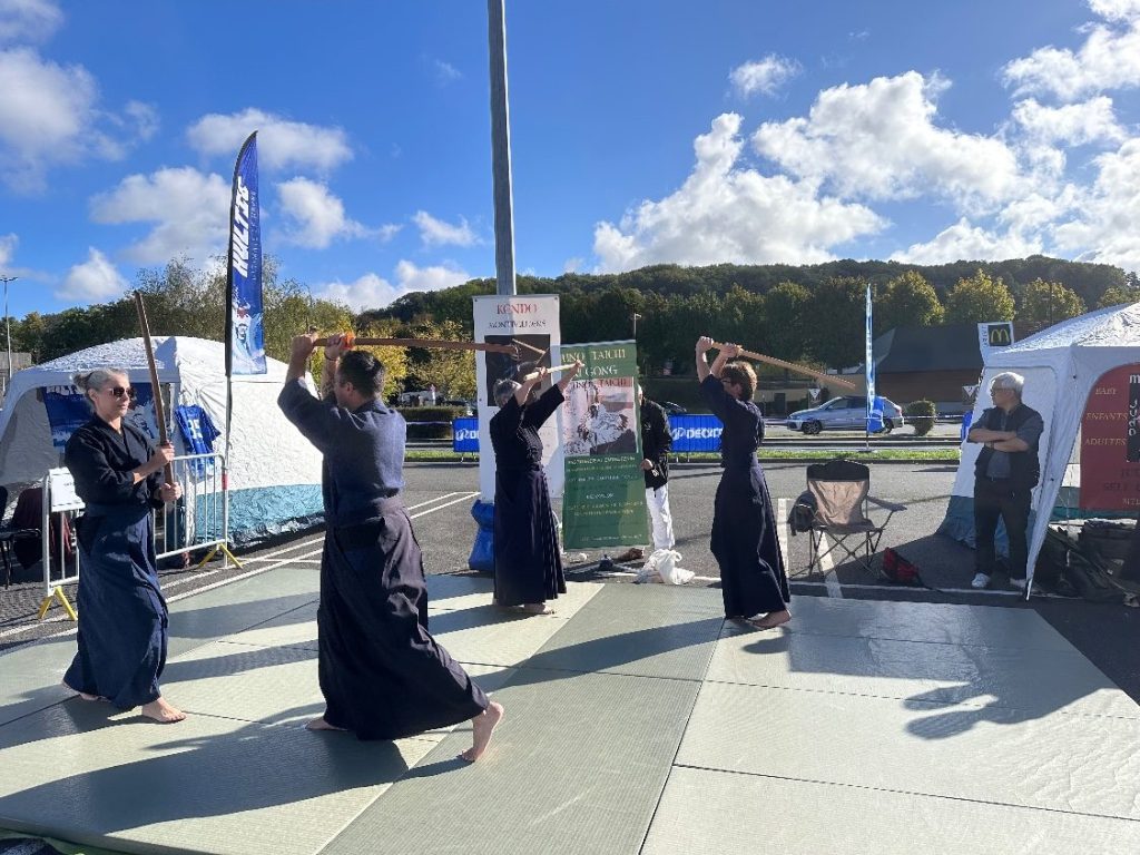 Les kendoka du club en démonstration collective, bokuto levé, sur le parking Decathlon