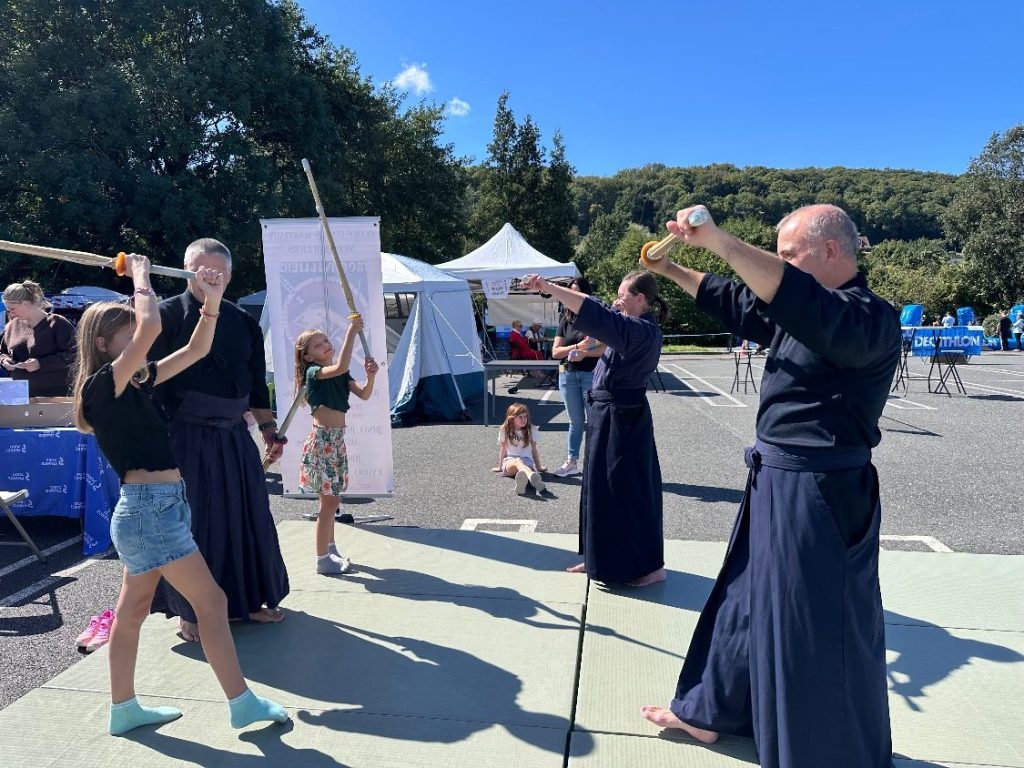 Enfants du public s'essayant au suburi, le geste de coupe de base du kendo